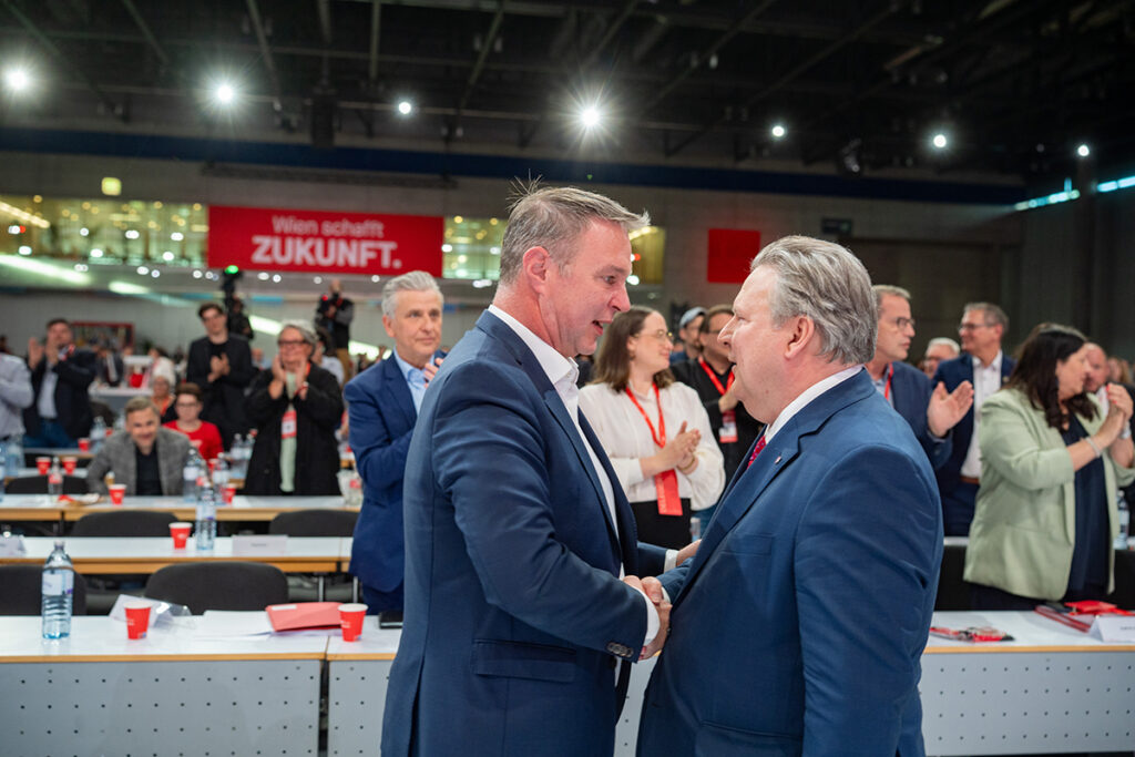 Federal Başkan Andreas Babler ve Viyana Belediye Başkanı Michael Ludwig sahnede el sıkışıyor.