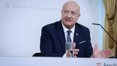 Avusturya Başbakanı Christian Stocker, Viyana'da bütçe mutabakatı basın toplantısında konuşurken. Arka planda "Republik Österreich" yazısı ve Avusturya bayrağı amblemi görülüyor.