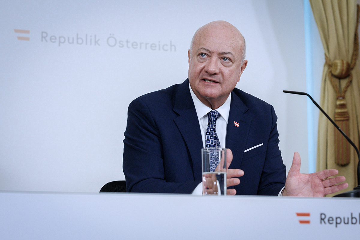 Avusturya Başbakanı Christian Stocker, Viyana'da bütçe mutabakatı basın toplantısında konuşurken. Arka planda "Republik Österreich" yazısı ve Avusturya bayrağı amblemi görülüyor.