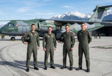 Brezilya'da Embraer C-390 askeri nakliye uçağı önünde poz veren dört Avusturyalı pilot