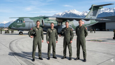 Brezilya'da Embraer C-390 askeri nakliye uçağı önünde poz veren dört Avusturyalı pilot