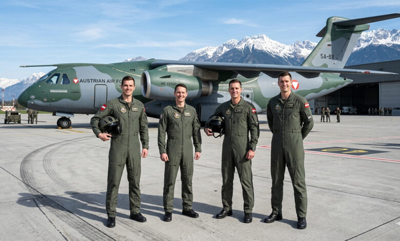 Brezilya'da Embraer C-390 askeri nakliye uçağı önünde poz veren dört Avusturyalı pilot