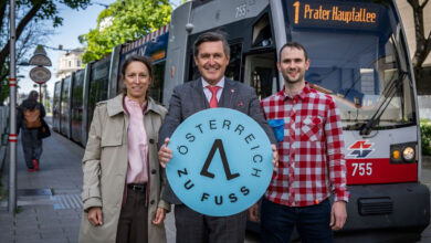Peter Hanke ve beraberindekiler Avusturya Yuruyor logosuyla tramvay onunde poz veriyor