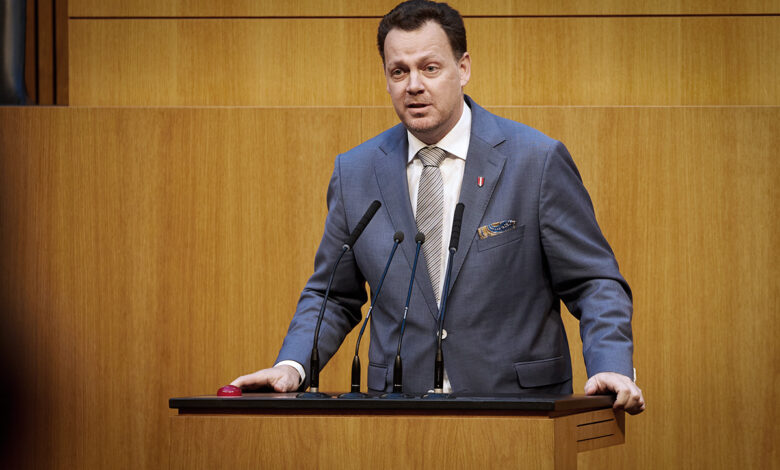 FPÖ Sağlık Sözcüsü Gerhard Kaniak, Avusturya Parlamentosu kürsüsünde takım elbisesiyle mikrofonlar önünde konuşma yapıyor.