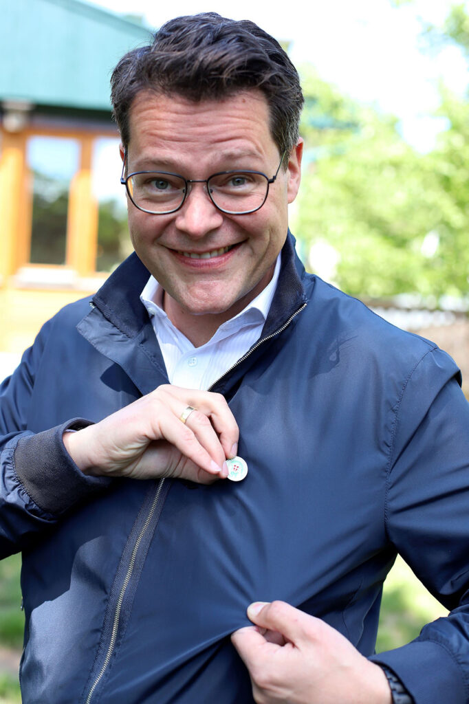 Viyana İklim Stadtrat'ı Jürgen Czernohorszky, doğa yürüyüşü sonrası kazandığı altın rengi Viyana Yürüyüş İğnesi'ni (Wandernadel) ceketinde gösterirken.