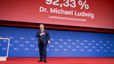 Viyana Belediye Başkanı Dr. Michael Ludwig, arkasında yüzde 92,33 oy oranını gösteren dev ekranın önünde sahnede elini kalbine götürerek teşekkür ediyor.