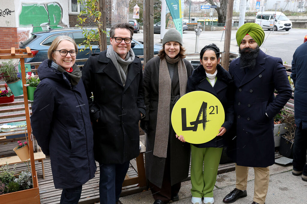 Penzing'de bir parklet önünde LA 21 logosu tutan proje gönüllüleri ve yetkililer.