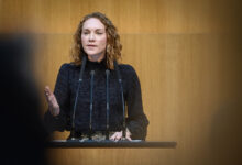 SPÖ Milletvekili Pia Maria Wieninger, Avusturya Ulusal Meclisi kürsüsünde mikrofonlar önünde konuşma yaparken.