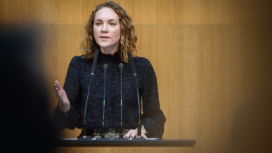 SPÖ Milletvekili Pia Maria Wieninger, Avusturya Ulusal Meclisi kürsüsünde mikrofonlar önünde konuşma yaparken.