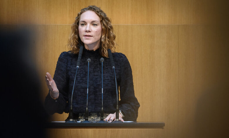 SPÖ Milletvekili Pia Maria Wieninger, Avusturya Ulusal Meclisi kürsüsünde mikrofonlar önünde konuşma yaparken.