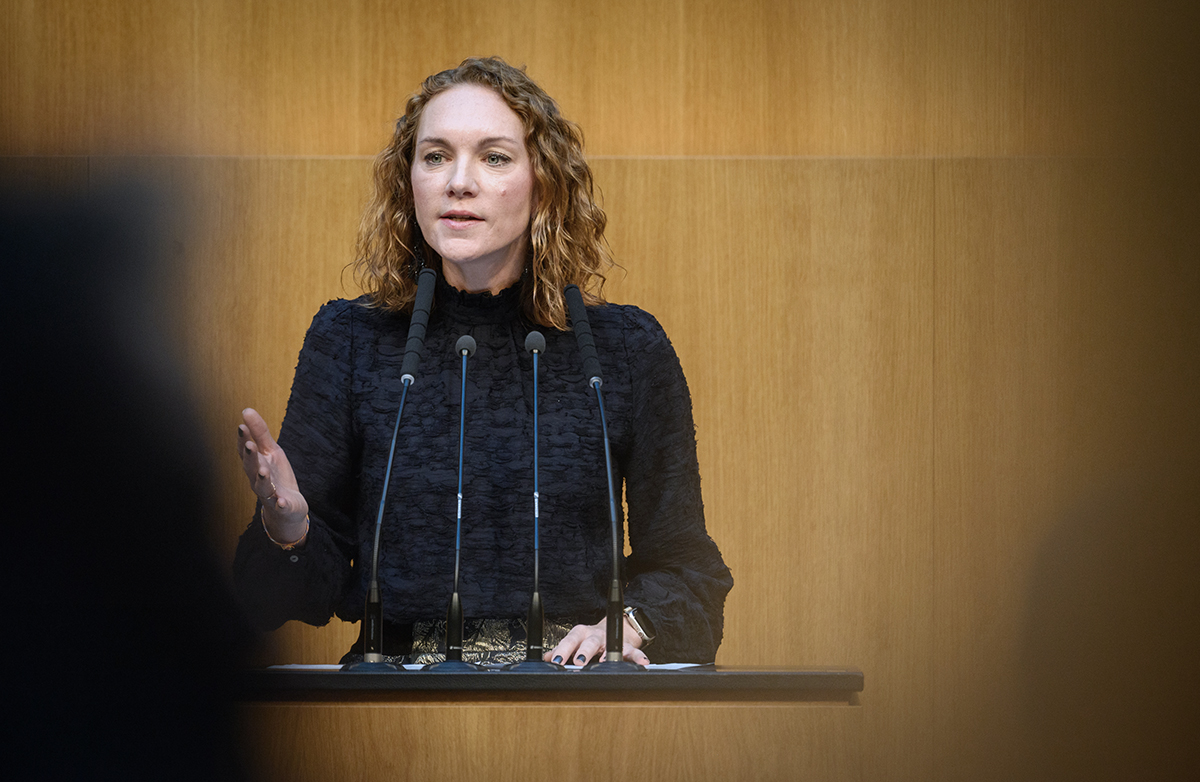 SPÖ Milletvekili Pia Maria Wieninger, Avusturya Ulusal Meclisi kürsüsünde mikrofonlar önünde konuşma yaparken.
