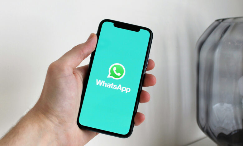 WhatsApp logosu açık akıllı telefon tutan el - WhatsApp numaram kimde kayıtlı öğrenme yöntemi