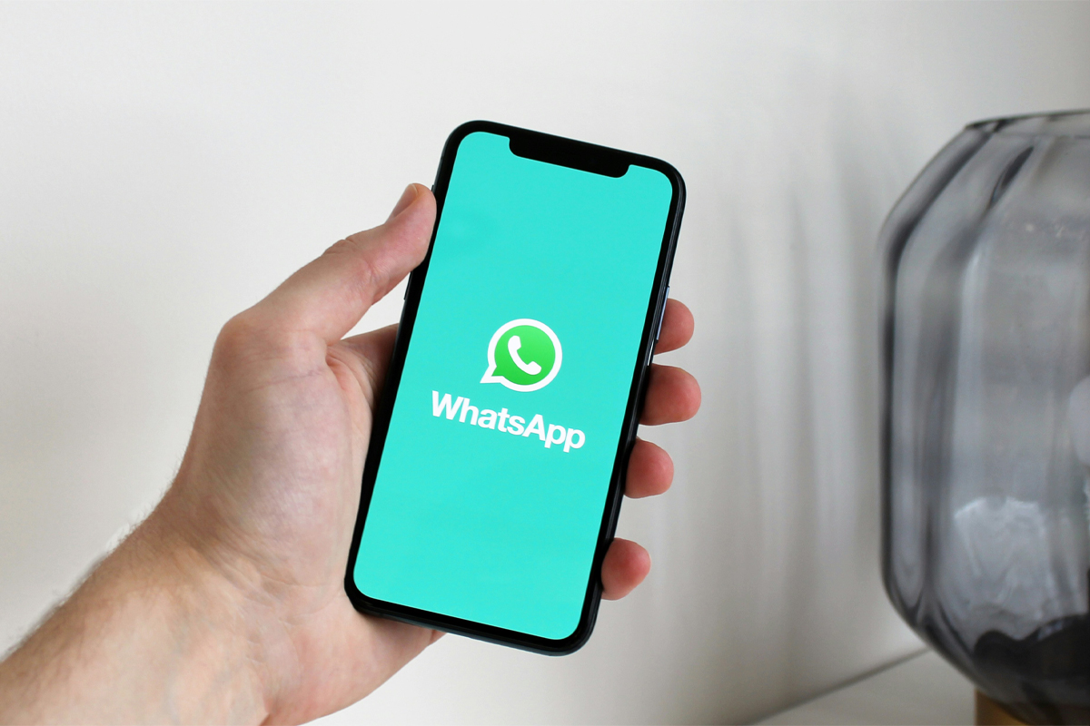 WhatsApp logosu açık akıllı telefon tutan el - WhatsApp numaram kimde kayıtlı öğrenme yöntemi