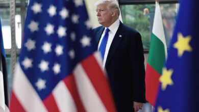 Donald Trump AB ve ABD bayrakları arasından geçerken transatlantik ittifakındaki çatlağı simgeleyen görsel.