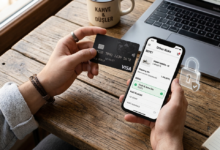 Bir elinde kredi kartı diğer elinde akıllı telefon ile online alışveriş yapan bir kişi ve ekrandaki güvenlik kilidi sembolü.