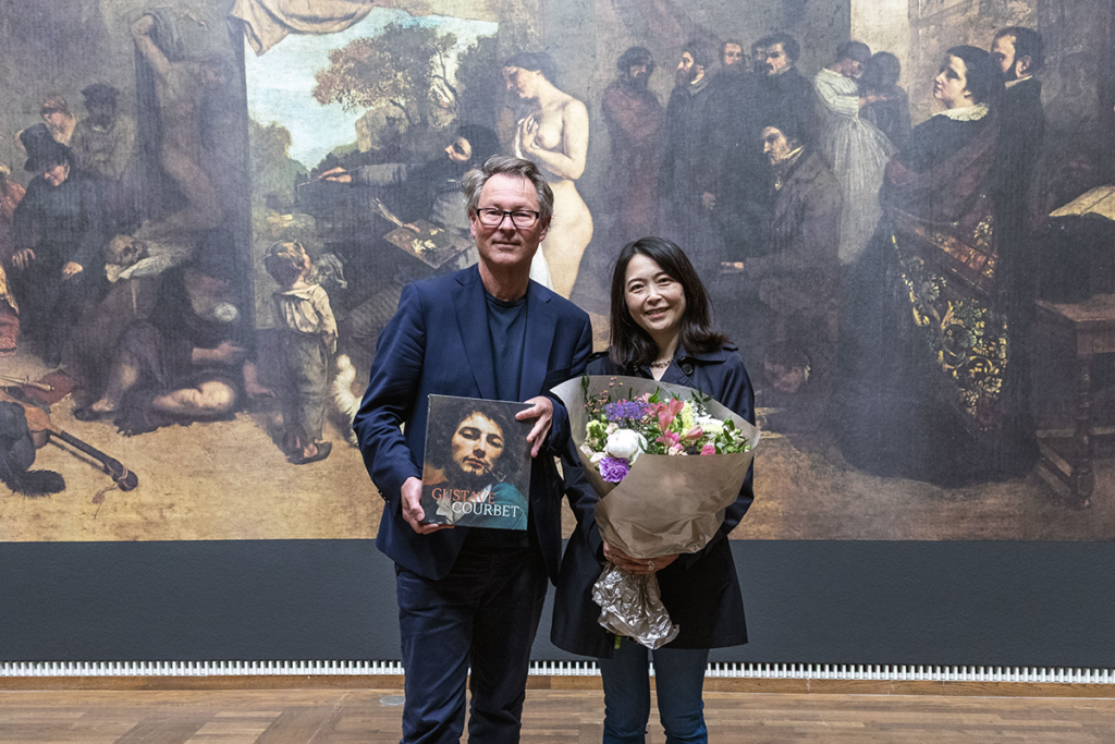 Leopold Museum Müdürü Hans-Peter Wipplinger ve 100 bininci ziyaretçi Yuki Aoki, Gustave Courbet'nin Sanatçının Atölyesi tablosu önünde.
