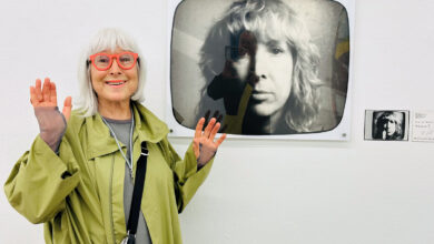 Feminist sanatçı Margot Pilz, Viyana'da kendi eski eserinin önünde gülümseyerek poz veriyor.