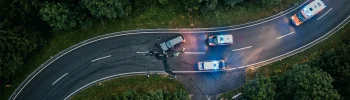 Avusturya'da virajlı bir orman yolunda meydana gelen trafik kazası yerinin drone ile havadan çekilmiş kuş bakışı temsili fotoğrafı.