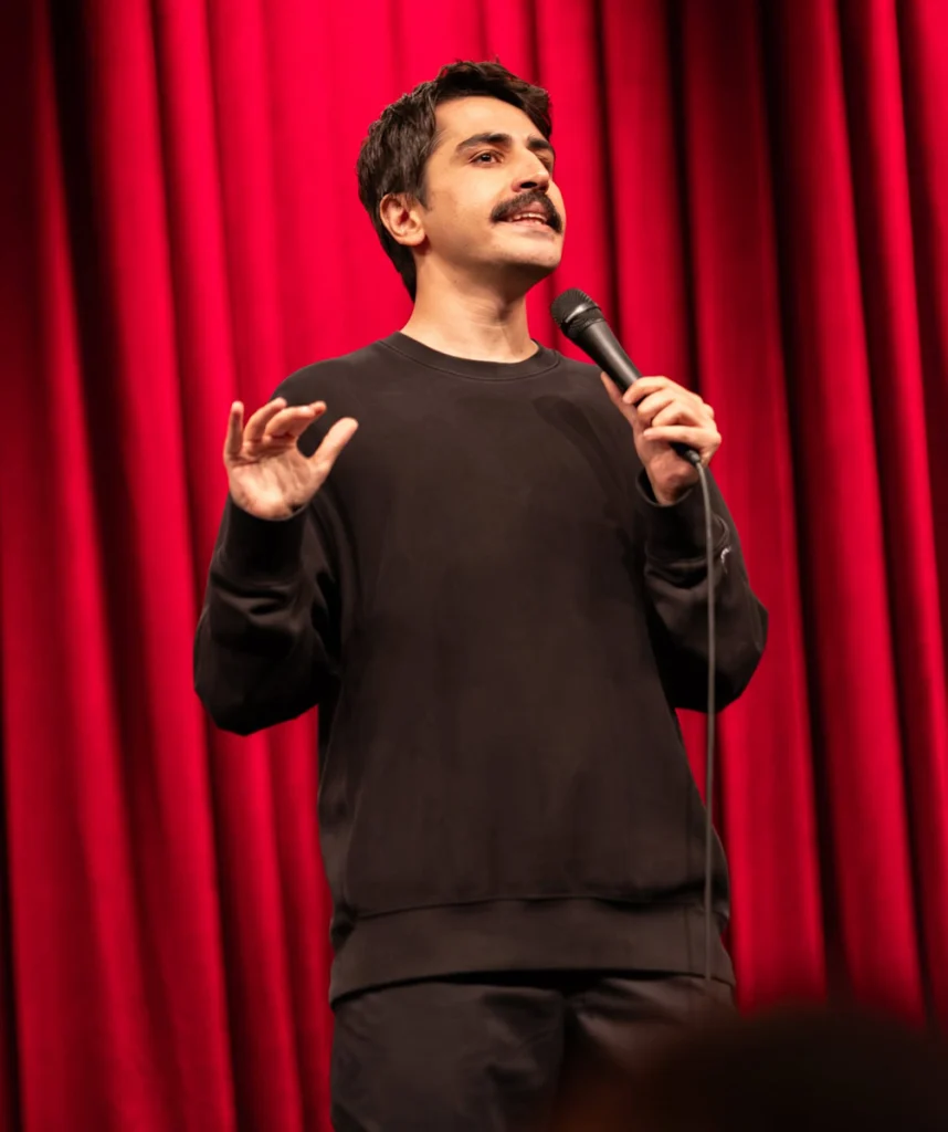 Deniz Göktaş sahnede elinde mikrofonla konuşurken yakın plan detay fotoğrafı