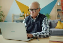 Avusturya'da dizüstü bilgisayar üzerinden ID Austria ile online Pensionskonto emeklilik hesabı sorgulaması yapan kıdemli bir çalışan.