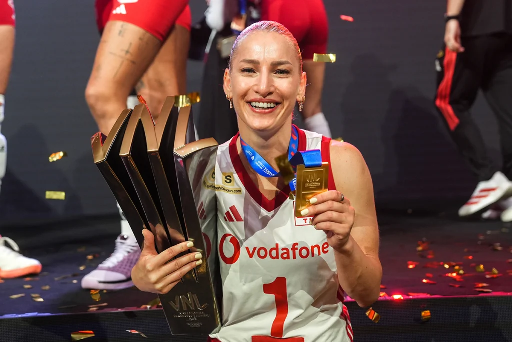 A Milli Kadın Voleybol Takımı kaptanı Gizem Örge, 1 numaralı formasıyla elinde 2026 VNL şampiyonluk kupasını ve altın madalyasını tutarak gülümsüyor.