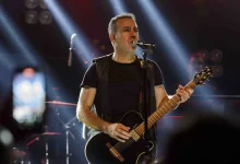 Haluk Levent konser sırasında sahnede elinde gitar mikrofonla şarkı söylerken.